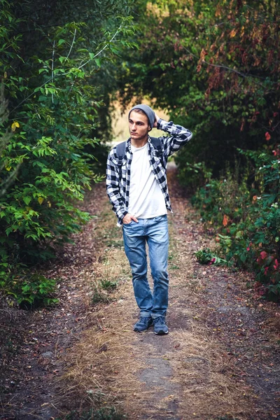 森の中でバックパック放浪者で若いハンサムな男の肖像を歩く — ストック写真