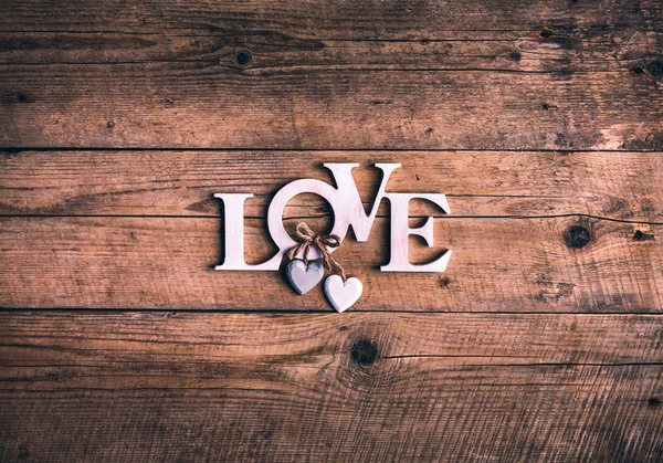 Деревянные буквы образуют слово ЛЮБОВЬ, написанное на деревянном фоне. День Святого Валентина. два сердца — стоковое фото