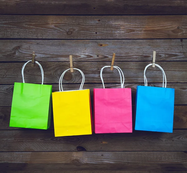 Růžový nákupní tašky na dřevěné pozadí, prodej, nákup — Stock fotografie