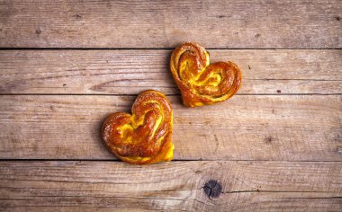 Ev yapımı hamur işleri. Ahşap arka plan üzerinde topuz kalp. Gıda