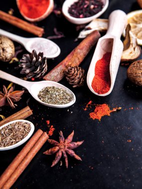siyah arka plan üzerine baharat ile tahta kaşıklar