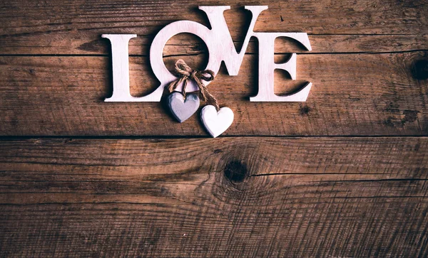 Dřevěné písmena tvoří slovo láska na dřevěné pozadí. Den svatého Valentýna. dvě srdce — Stock fotografie