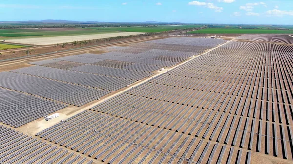 田舎の農業地帯を背景に広大な太陽光発電所を空中から眺め ロイヤリティフリーのストック写真