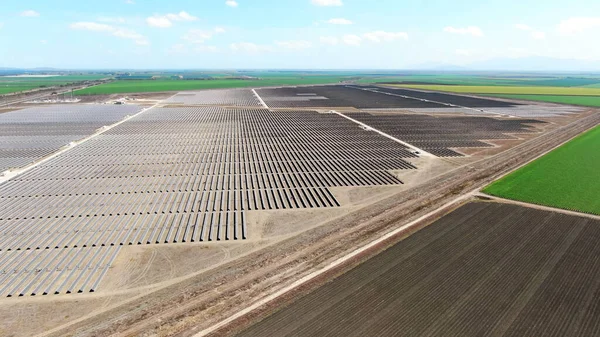 田舎に耕された農地のある広大な太陽光発電所の空中からの眺め ロイヤリティフリーのストック画像
