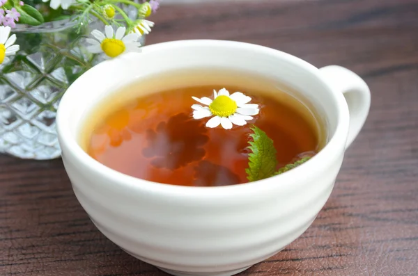 Tea with chamomile and leaves — Stock Photo, Image