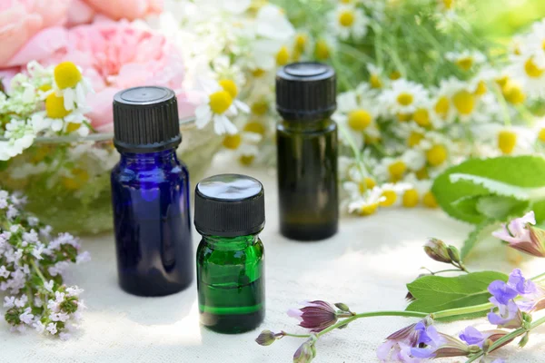 Essential oils with herbal flowers — Stock Photo, Image