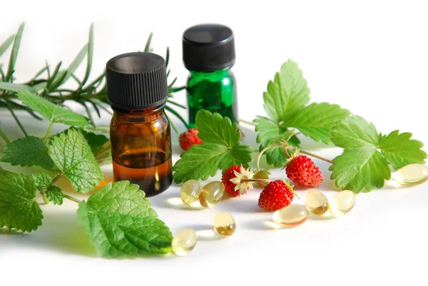 Essential oils and supplement with fruits and herbs — Stock Photo, Image