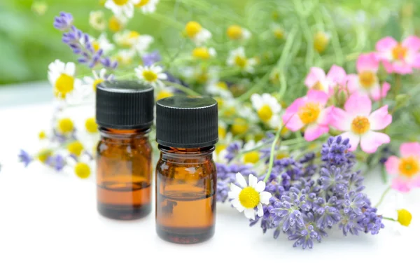 Essential oils with herbal flowers — Stock Photo, Image