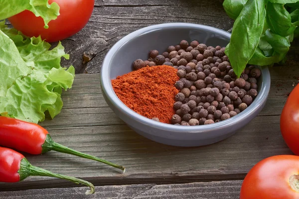 Especiarias na velha mesa de madeira com legumes . — Fotografia de Stock