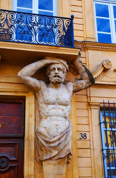 Fransa 'nın güneyindeki Aix-en-Provence' de bir balkonun altındaki bir binada erkek heykelleri.
