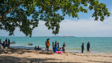 Lumumsia, Malezya. 16 Mayıs 2015: Halkın ya da turistin Teluk Senangin, Lumut, Perak 'ta piknik yaptığı ve akşam plaj dinlenmesinin keyfini çıkardığı manzara ve etkinlik.