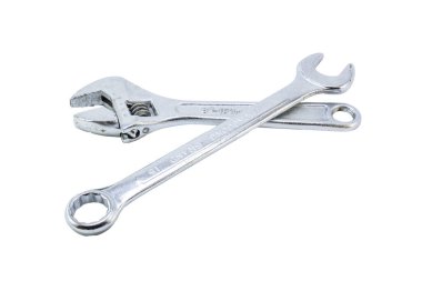 Ayarlanabilir bir anahtar ve İngiliz anahtarı, ikisi de krom kaplamalı, beyaz arka planda kesişiyorlar..