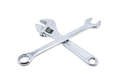 Ayarlanabilir bir anahtar ve İngiliz anahtarı, ikisi de krom kaplamalı, beyaz arka planda kesişiyorlar..