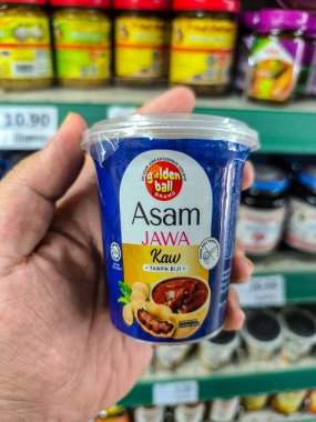 PERAK, MALAYSIA - 22 Ekim 2025: Bir süpermarkette küçük bir tüp Altın Top Asam Jawa Kaw (çekirdeksiz demirhindi ezmesi) tutmaktadır.