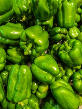 Yakın plan, yüksek açılı canlı, parlak yeşil dolmalık biber yığını..