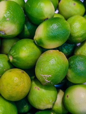 Yakından, yüksek açılı taze, yeşil ve sarı tonlu limonların olduğu bir yığın..