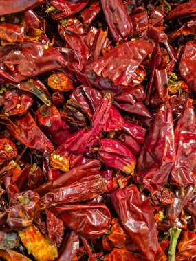 Parlak ışıkta kırmızı, buruşuk, kurutulmuş kırmızı biberlerin yakın çekimi..
