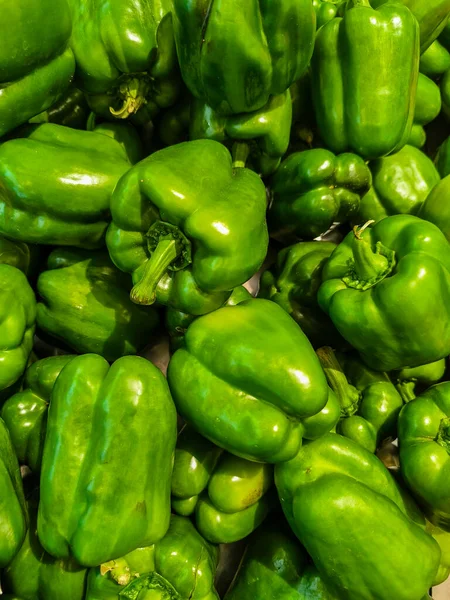 Yakın plan, yüksek açılı canlı, parlak yeşil dolmalık biber yığını..