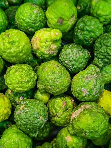 Engebeli dokusu olan taze yeşil kaffir limonlarının yakın çekim, tepeden çekimi..