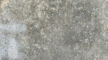 Yaşlanmış, benekli beton bir yüzeyin doğal hava akımı ve gri-bej dokularla detaylı bir fotoğrafı..
