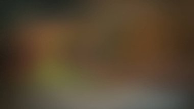 Yumuşak, odak dışı soyut bir arkaplan. Kahverengi, zeytin yeşili ve koyu gri gibi ılık toprak tonlarının karışımı pürüzsüz bir gradyan oluşturur..