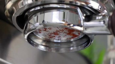Espresso makinesi dipsiz iskele filtresi. Düşük açı. Kahve kremalı damlalar dökerken yakın görüş..