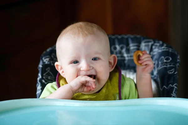 6 month old baby eat at the kids 'table — стоковое фото