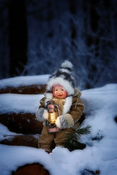 Маленька дитина в зимовому лісі з ліхтарем — стокове фото