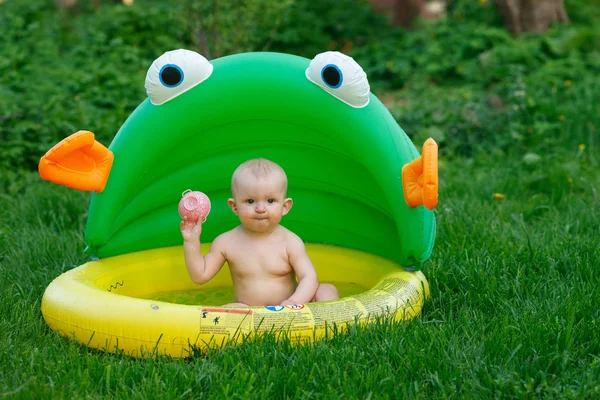 El niño está bañado en una piscina inflable — Foto de Stock