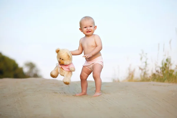 El niño está de pie con un juguete de peluche en las manos de — Foto de Stock