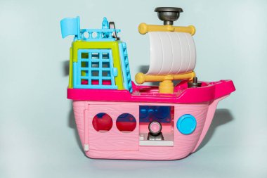 Mavi arka planda, plastik pembe oyuncak gemisi..