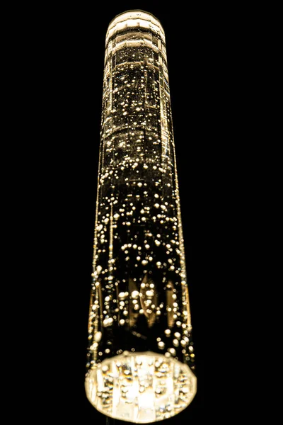 Um lustre de vidro pendura do teto em um fundo escuro — Fotografia de Stock
