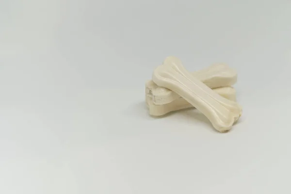 Artificial um osso de um cão com vitaminas no fundo branco — Fotografia de Stock