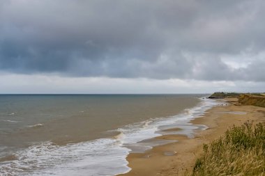 Fırtınalı bir akşamda Norfolk sahilindeki Happisburgh plajına bakın.