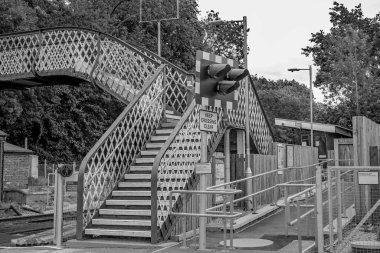 Brundall, Norfolk, İngiltere - 22 Temmuz 2020. Brundall 'ın Norfolk köyündeki demiryolu hattının üzerindeki eski metal yaya köprüsünün siyah ve beyaz resimli bir resmi.