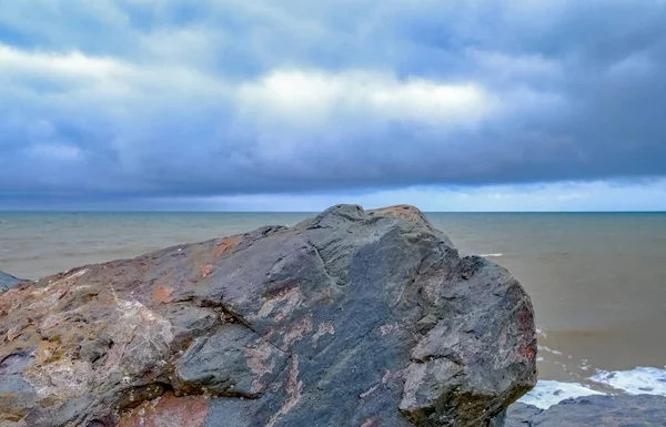 Kuzey Denizi üzerindeki kara fırtına bulutları Norfolk sahilindeki Happisburgh sahilindeki kayalık deniz savunmasından ele geçirildi.