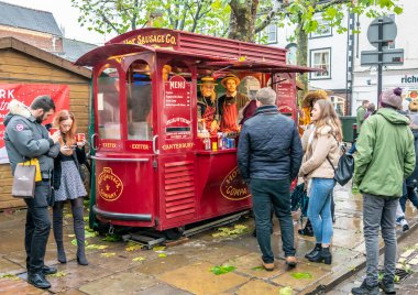 York, İngiltere, - 23 Kasım 2019. York 'taki Noel pazarındaki bir sokak satıcısından sosisli sandviç kuyruğu oluşturan resimli editör fotoğrafı.