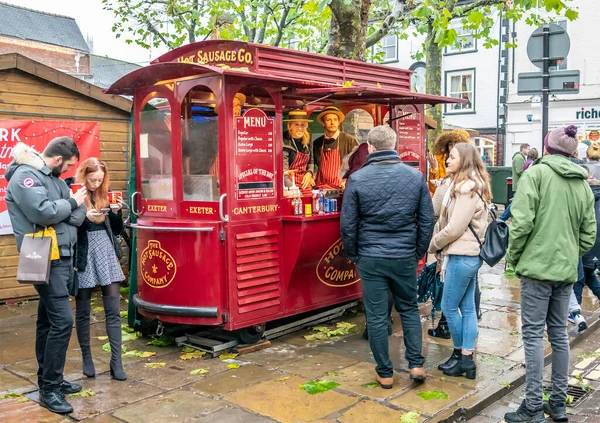 York, İngiltere, - 23 Kasım 2019. York 'taki Noel pazarındaki bir sokak satıcısından sosisli sandviç kuyruğu oluşturan resimli editör fotoğrafı.