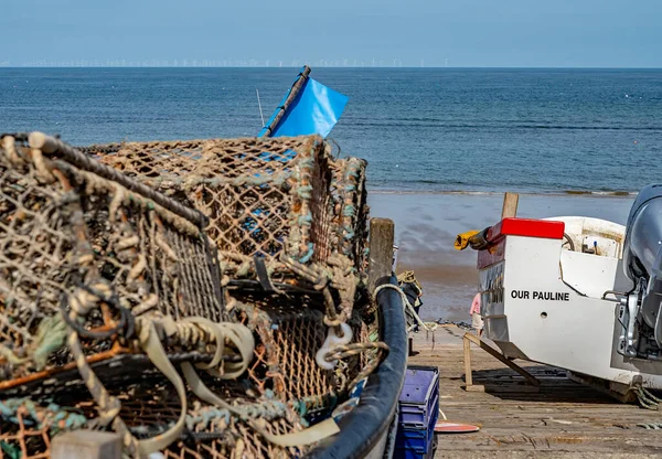 Close up of lobster pots and fishing boat on the beach in the coastal town of Sheringham Norfolk