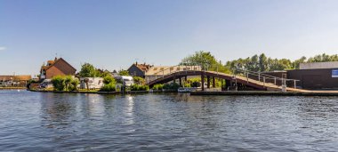 Wroxham, Norfolk, İngiltere - 22 Haziran 2019. Norfolk Broads 'un kalbindeki küçük bir köy olan Wroxham nehrinin üzerindeki küçük bir köprünün illüstrasyon fotoğrafı.