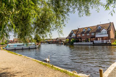 Wroxham, Norfolk, İngiltere - 22 Haziran 2019. Güzel bir bayram nehir kenarı tatilinin resmedilmiş resmi Norfolk Hatunları 'nın merkezindeki Wroxham köyündeki Bure nehrinin kıyısında ağaçların altında yakalandı. 