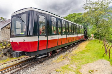 Snowdon Dağı Demiryolu, Llanberis, Kuzey Galler - 01 Temmuz 2019. Yolcuları Snowdon Dağı 'nın zirvesine taşıyan dizel bir trenin illüstrasyon fotoğrafı.