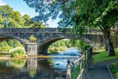 Severn Nehri 'nin üst kısımlarında Llanidloes parkında, Galler' in ortasında, taştan köprüyle birlikte.