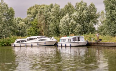 Güney Walsham, Norfolk, İngiltere - 08 Temmuz 2019. Güney Walsham 'daki Norfolk Hatunları' ndaki Bure Nehri 'nin bir uzantısı olan Fleet Dyke' a demirlenmiş tatil teknelerinin resimli bir resmi.