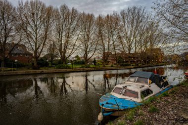 Norwich, Norfolk, İngiltere - 29 Aralık 2019. Norwich şehrindeki Wensum Nehri 'nde demirlemiş tamir edilmesi gereken terk edilmiş bir teknenin illüstrasyon fotoğrafı.