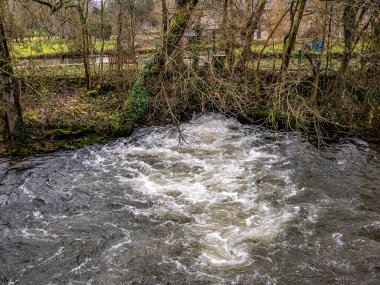 Su, Wye Nehri 'nden taşmış bir kanalda akıyor.