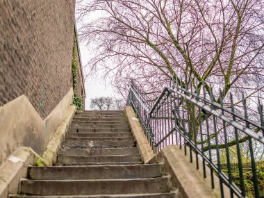 Kış günü taş duvara tırmanan beton adımlara özen gösterin.