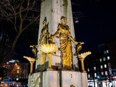 Aachen, Almanya - 07 Aralık 2019. Almanya 'nın Aachen kentindeki su çeşmesinin tepesindeki altın heykellerin resimli resmi.