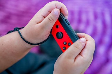 Norwich, Norfolk, İngiltere - 25 Aralık 2019. Bir Nintendo Anahtarı oyun konsolunun kırmızı denetleyicisini tutan tanımlanamayan bir çocuğun resimli editör fotoğrafı