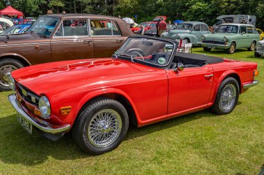 Wroxham, Norfolk, İngiltere - 21 Temmuz 2019. Klasik bir Triumph TR6 spor otomobilinin, Wroxham 'daki yıllık klasik araba fuarında, parlak kırmızı renkte, yan görünüşünün resimli bir resmi.